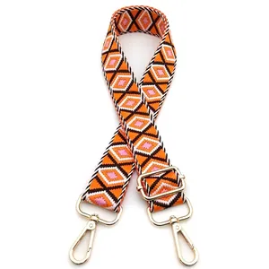 Macro detail of adjustable woven bag strap with colorful diamond pattern and gold hardware