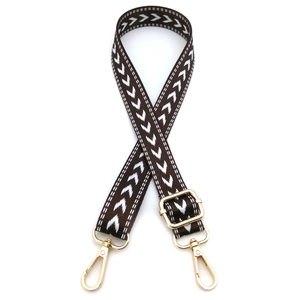 Detail view of adjustable dark brown crossbody bag strap with white arrow pattern