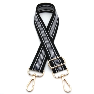 Adjustable black and white striped woven shoulder strap with gold metal hooks and hardware