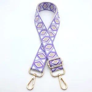Macro detail of purple and brown diamond pattern woven strap with gold swivel hooks