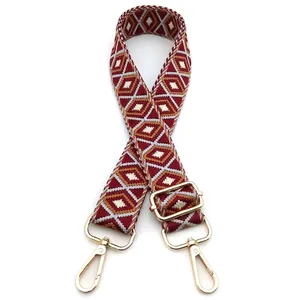 Close-up of adjustable woven strap with red and brown geometric diamond pattern and gold clips