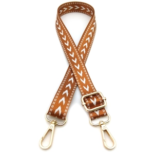 Detail of brown woven bag strap with white arrow patterns and gold lobster clasps