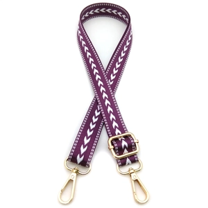 Detail of adjustable bag strap with white arrow pattern and golden metal swivel hooks