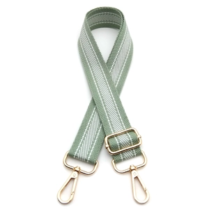 Adjustable light green canvas bag strap with white twill pattern and gold metal hooks