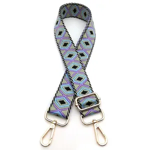 Detail of adjustable geometric diamond pattern bag strap with gold metal buckles