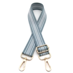 Adjustable crossbody bag strap featuring blue and white herringbone weave and gold hooks