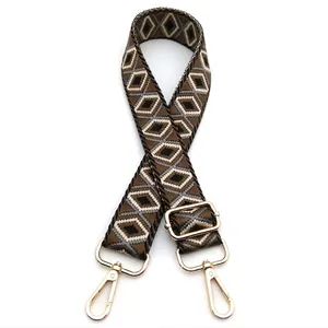Detail of adjustable geometric diamond pattern bag strap with gold metal hardware