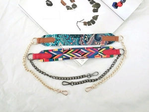 Detail view of woven guitar straps and metal chains for handbags on white fabric background