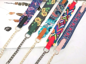 Detail showing five stylish patterned handbag straps with decorative metal chains