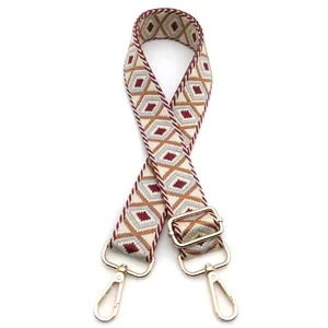 Detail of adjustable bohemian embroidered bag strap with vintage diamond patterns and gold hooks