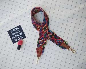 Close-up of bohemian colorful woven bag strap with golden metal swivel hooks