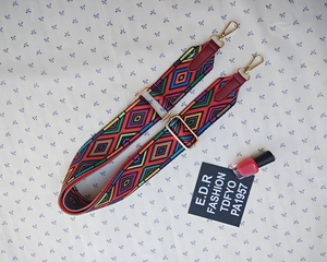 Close-up of colorful ethnic geometric woven shoulder strap with gold metal hooks