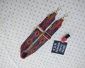 Detail of bohemian jacquard woven bag strap with golden metal swivel hooks and leather ends