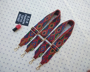 Detail of adjustable colorful woven shoulder straps with geometric ethnic patterns and gold hooks