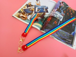 Close-up of rainbow striped nylon lanyards with red leather ends and gold metal lobster clasps