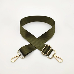 Macro shot of army green nylon bag strap with high-gloss gold lobster clasps and buckles