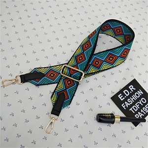 Detail of bohemian geometric adjustable wide strap with golden metal swivel hooks