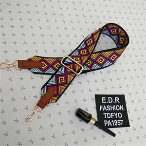 Detail of adjustable ethnic geometric pattern shoulder strap with golden metal clasps