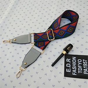 Detail of colorful geometric woven bag strap with adjustable gold buckles and leather ends