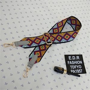 Close-up of bohemian geometric wide strap with golden metal buckles and faux leather ends