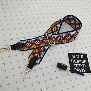 Detail of adjustable woven strap with colorful diamond pattern and golden metal hooks