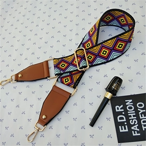 Detail of colorful geometric woven bag strap with golden lobster clasp and leather end