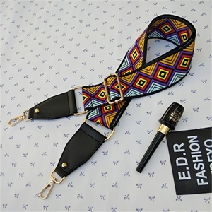 Detail of adjustable ethnic patterned jacquard shoulder strap with gold metal buckles