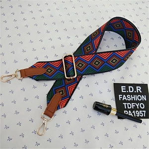 Detail of adjustable geometric ethnic style bag strap with gold metal buckle and leather ends