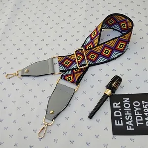 Close-up of adjustable colorful geometric woven strap with gold metal lobster clasps