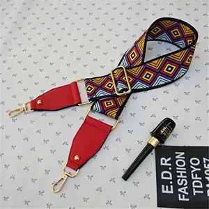 Detail of colorful geometric wide bag strap with red leather ends and gold metal hooks