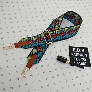 Detail of adjustable geometric ethnic bag strap with leather trim and gold metal hooks
