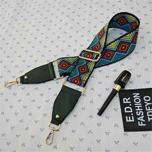 Detail of adjustable geometric patterned wide shoulder strap with golden metal clips