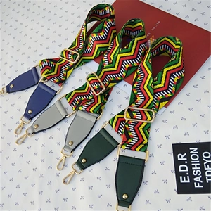 Close-up of colorful geometric woven bag straps with gold metal hooks and faux leather ends