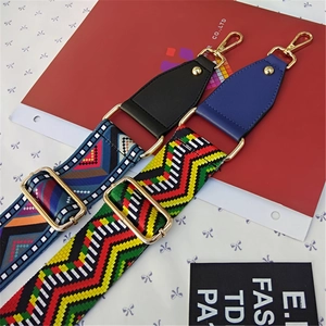 Detail of adjustable geometric and wave pattern bag straps with gold metal lobster clasps