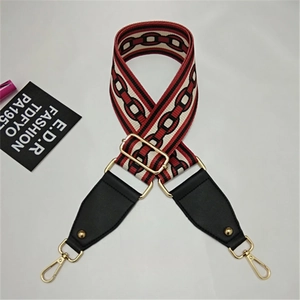 Detail of red and black geometric woven bag strap with golden alloy swivel hooks