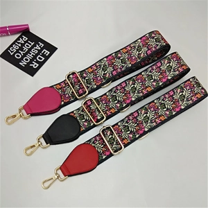 Detail view of wide ethnic floral bag straps with gold buckles and colorful PU leather ends