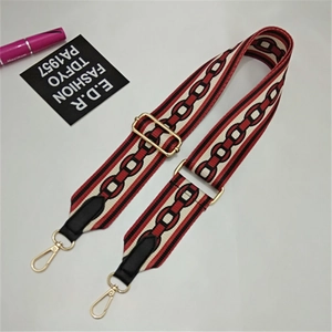 Detail of adjustable geometric canvas shoulder strap with gold metal lobster clasps