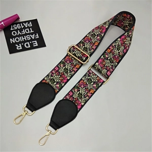 Detail showing vintage ethnic embroidery on adjustable wide shoulder strap with gold hardware