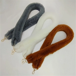 Detail view of plush faux fur shoulder straps in grey, cream, and brown with gold hooks