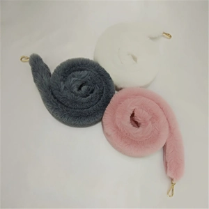 Detail of plush faux fur shoulder straps in grey, pink, and white with gold metal clasps
