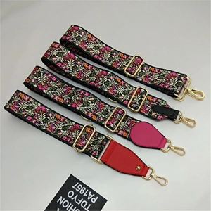 Detail of adjustable wide shoulder straps with floral embroidery and gold metal hooks