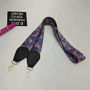 Close-up of paisley pattern on ethnic style wide bag strap with gold metal hooks