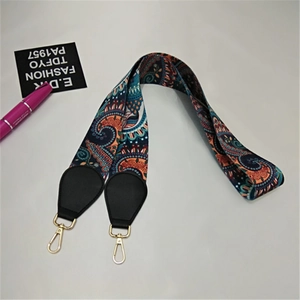 Close-up of bohemian style wide woven shoulder strap with gold metal hooks