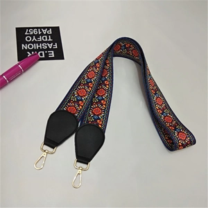 Detail of ethnic jacquard purse strap with gold hooks and black leather ends
