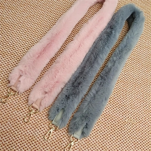 Detail of pink and gray faux fur wide bag straps with gold metal lobster clasps
