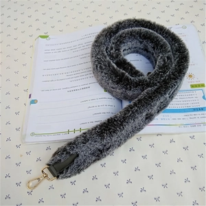 Detail of wide faux fur shoulder strap in grey with gold lobster clasps for bags