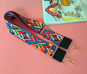 Close-up of colorful ethnic geometric pattern woven strap with gold metal buckles