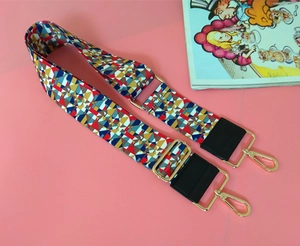 Detail of colorful geometric woven strap with golden metal hooks and black leather
