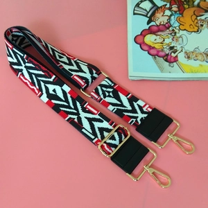 Adjustable bohemian geometric woven bag strap with golden hardware on pink background
