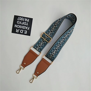 Close-up of geometric pattern on ethnic woven bag strap with golden metal hooks